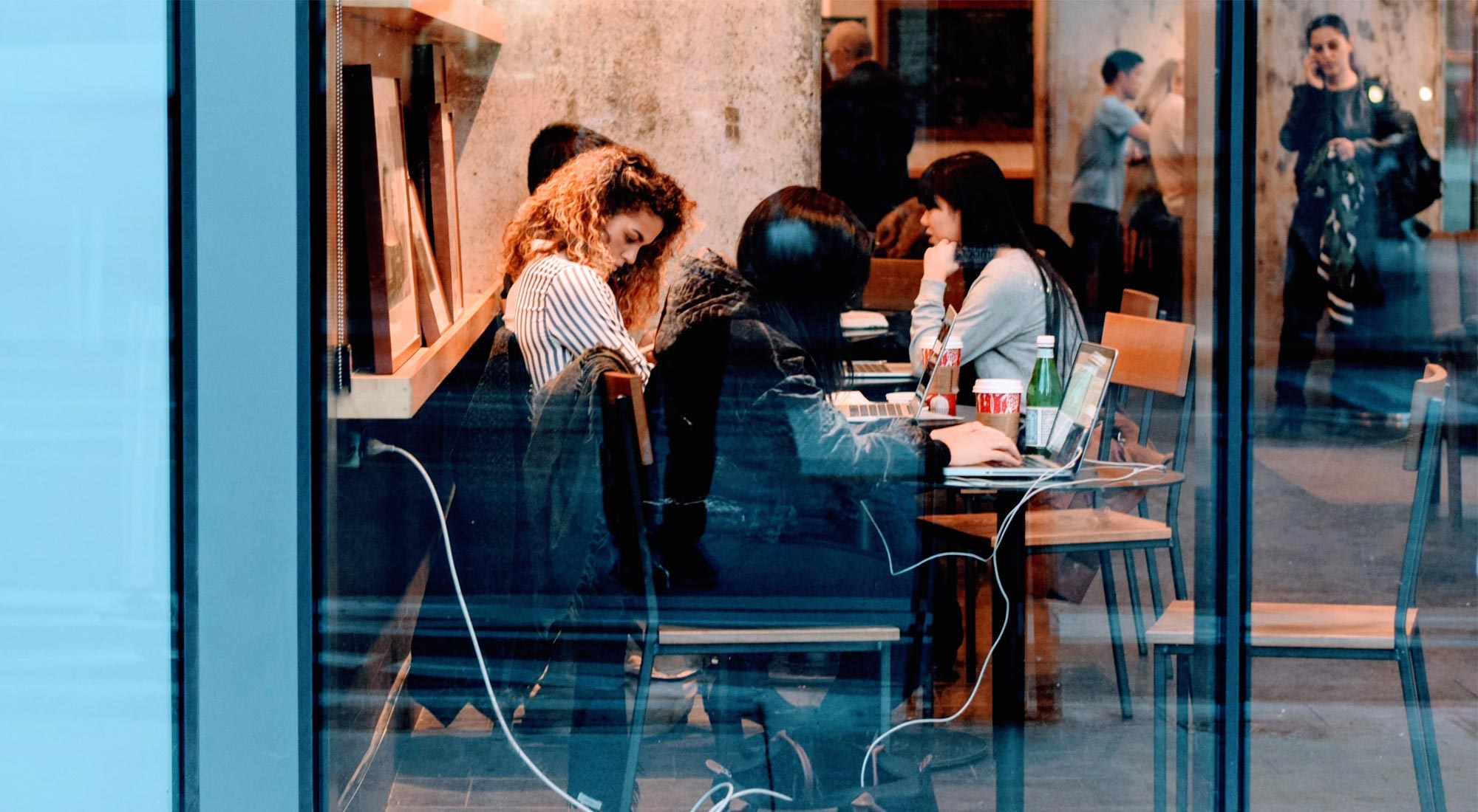 Women collaborating around a table at a coffee shop.