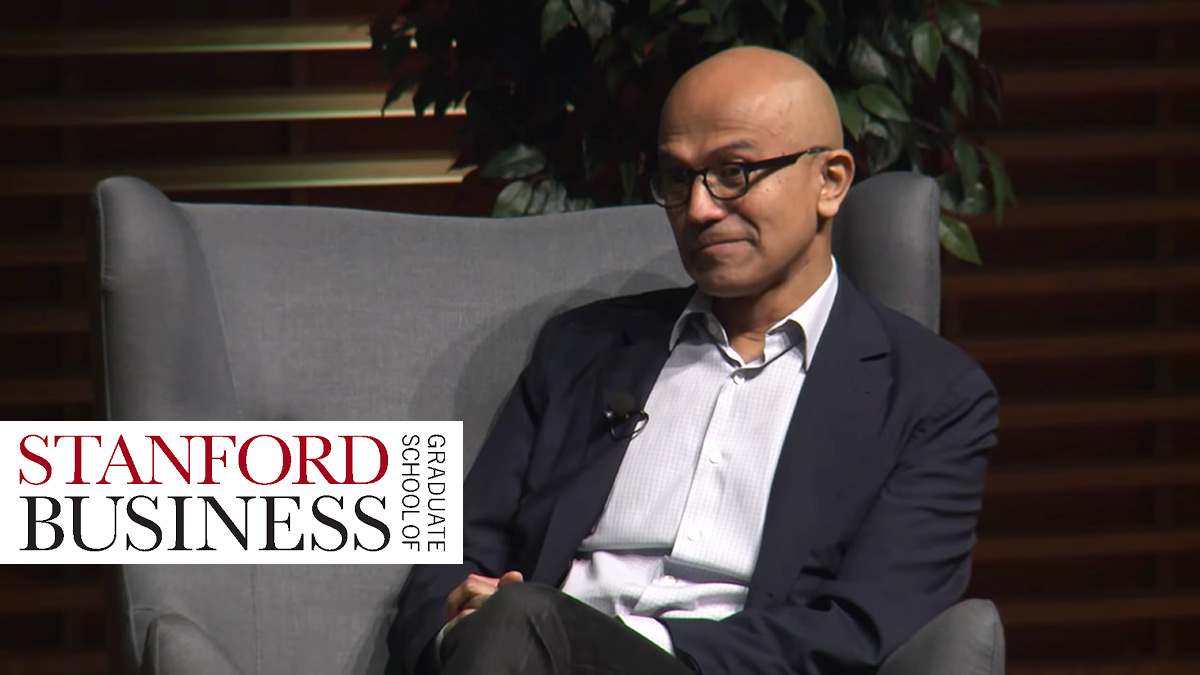 Satya Nadella sits on stage at the Stanford School of Business talking about empathy.