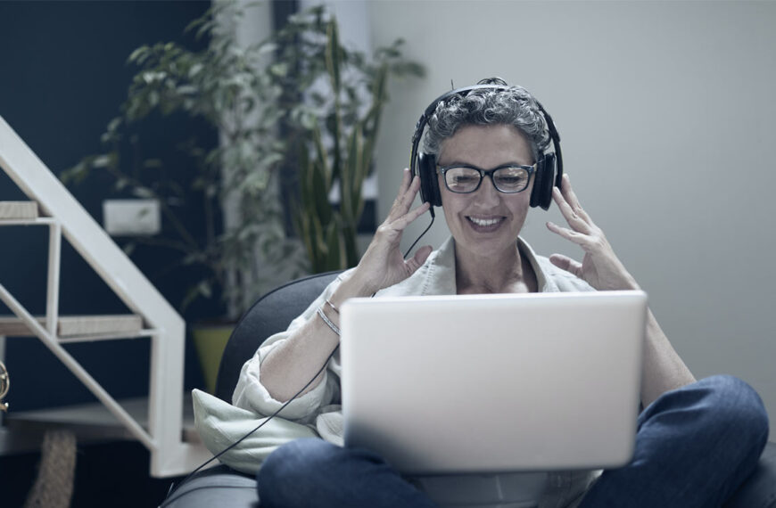 A coachee sits in their chair with their headset on laughing and smiling while being led through their EQ-i 2.0 debrief.