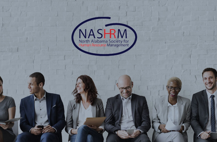 Several human resource professionals sit shoulder to shoulder, laughing together.